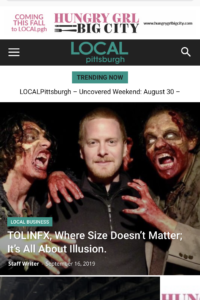 Steve Tolin stands between two actors in bloody zombie make-up with Local Pittsburgh Magazine Text layerd on top of the photo.