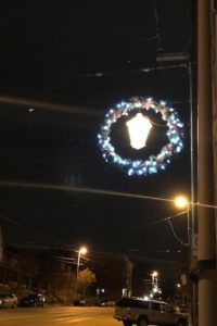 A lantern wreath hung on a telephone pole shines against the night sky of Beechview.