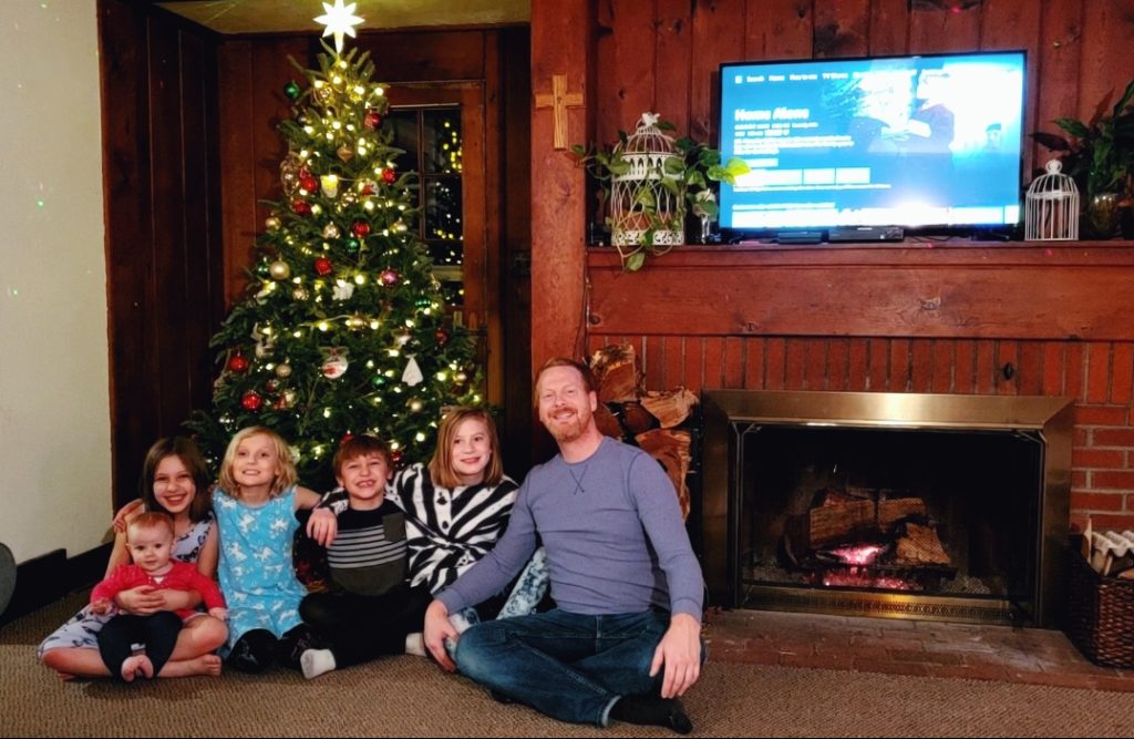 Steve Tolin poses with his 5 children in front of the Christmas tree in their home