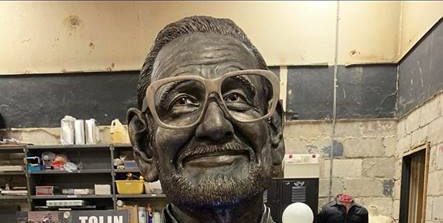 Larger than life sized sculpture of the face of George Romero in a bronze-paint finish.
